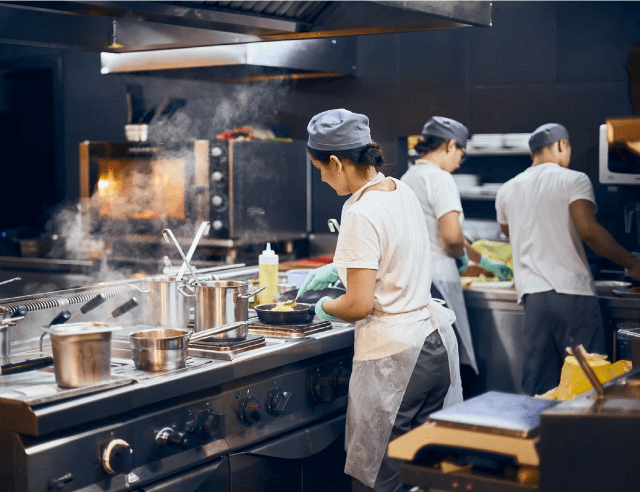 Cook A group of people in a kitchen preparing food.